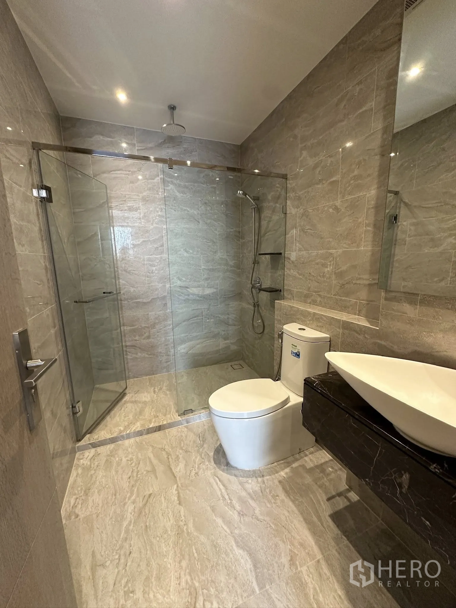 คอนโด for sale in Din Daeng, Bangkok - ห้องน้ำสมัยใหม่พร้อมตู้กระจกกันเปียก เรนชาวเวอร์ อ่างล้างหน้าแบบวางบนเคาน์เตอร์ และกระเบื้องลายหินอ่อน