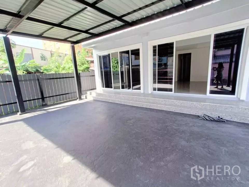 Home Office for rent in Bang Phli, Samut Prakan - Covered front terrace with metal roof and floor-to-ceiling sliding glass doors.