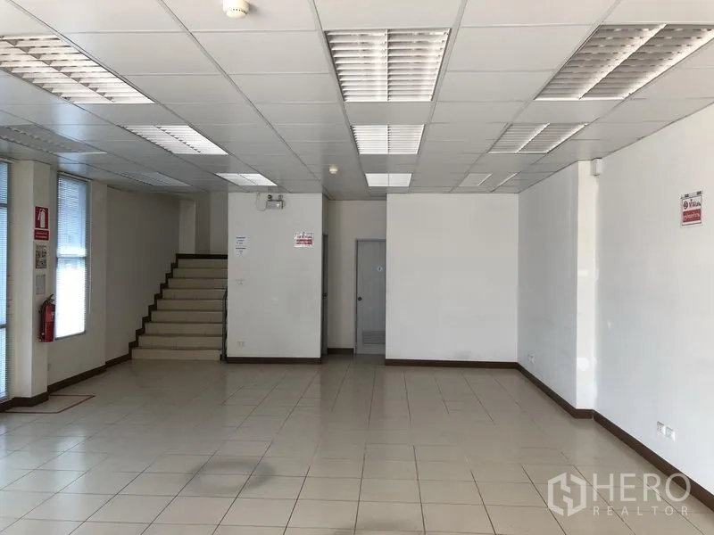 工厂 出租在Bang Sao Thong, Samut Prakan - 一层办公室，大块瓷砖地面与吊顶灯，旁有楼梯