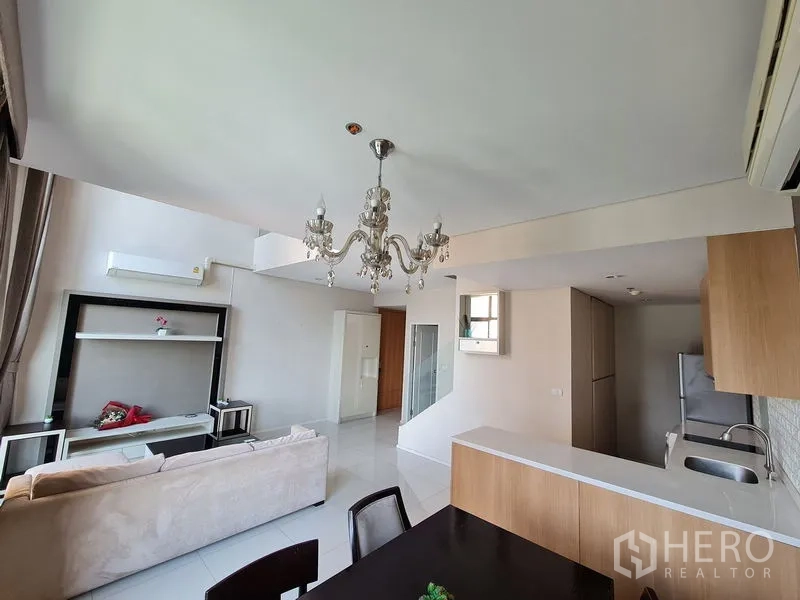 คอนโด ขายในRatchathewi, Bangkok - ครัวเปิดและโซนนั่งเล่นใต้แชนเดอเลียร์ในคอนโดสไตล์ลอฟท์