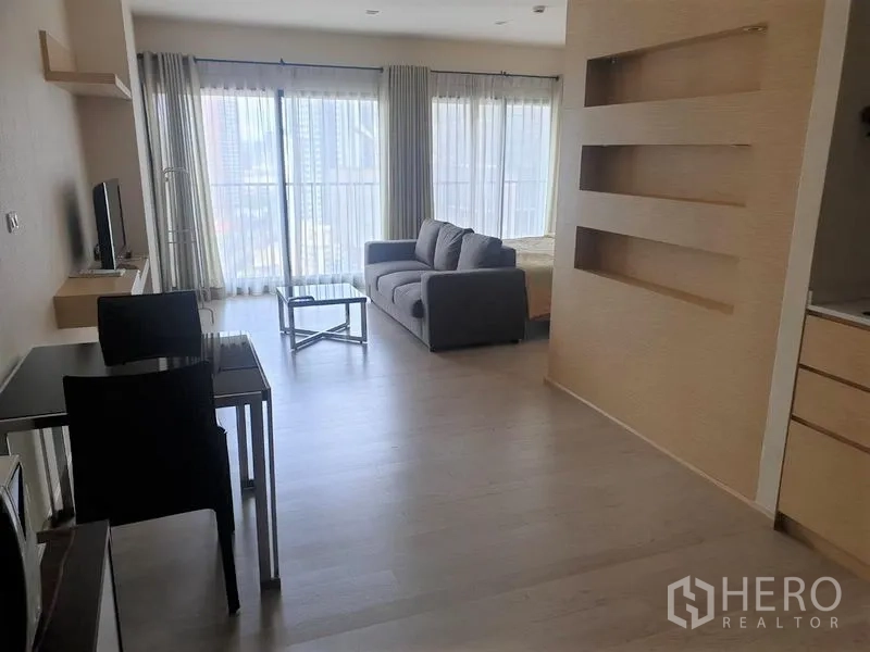 คอนโด ให้เช่าในKhlong Toei, Bangkok - ห้องนั่งเล่นแบบเปิดโล่ง กระจกเต็มบาน โซฟาสีเทา โต๊ะกระจก และระเบียงวิวเมือง