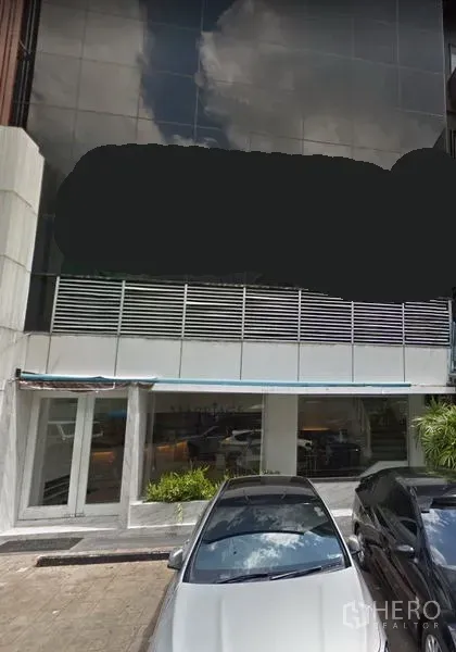 零售空间 出租在Khlong Toei, Bangkok - 现代玻璃幕墙临街零售建筑，一层门面与前方停车位，靠近曼谷BTS通罗站。