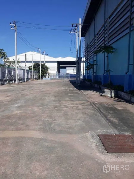 工厂 出租在Samut Prakan - 厂房侧边宽车道，电线杆与围栏清晰可见。