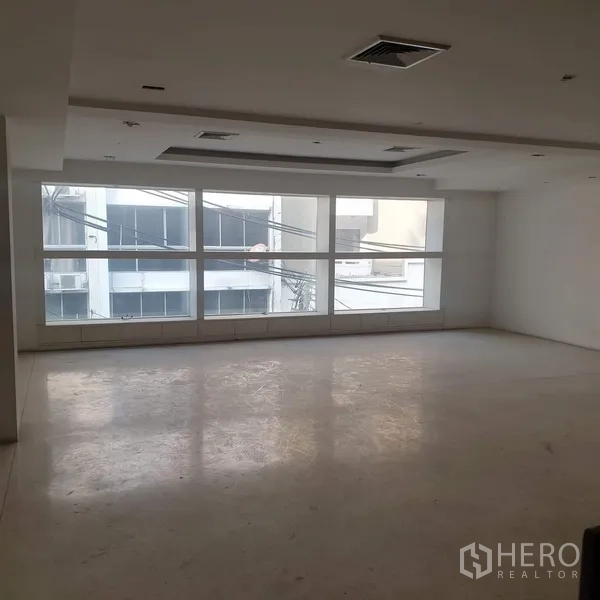 Home Office for rent in Khlong Toei, Bangkok - Bright office area with full-width windows and recessed ceiling lights.