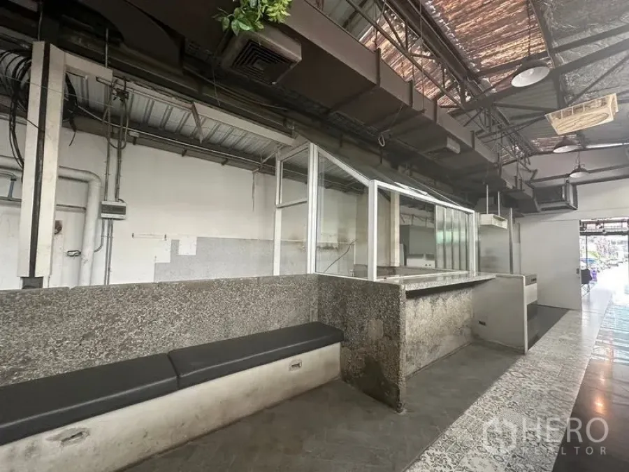 零售空间 出租在Bang Rak, Bangkok - 另一视角的花岗岩座位与零售柜台，面向入口和瓷砖地面。