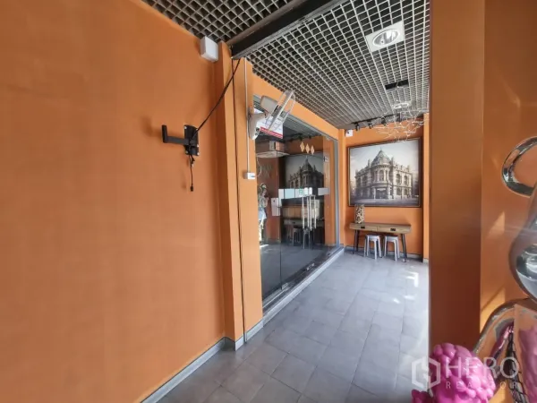 Shophouse for rent in Pathum Wan, Bangkok - Glass-front entrance lobby with orange walls and waiting bench.