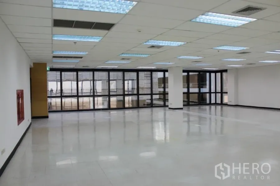 สำนักงาน ให้เช่าในWatthana, Bangkok - พื้นที่ทำงานเปิดโล่ง ไฟฟลูออเรสเซนต์ หน้าต่างกรอบดำ และตู้ดับเพลิงติดผนัง