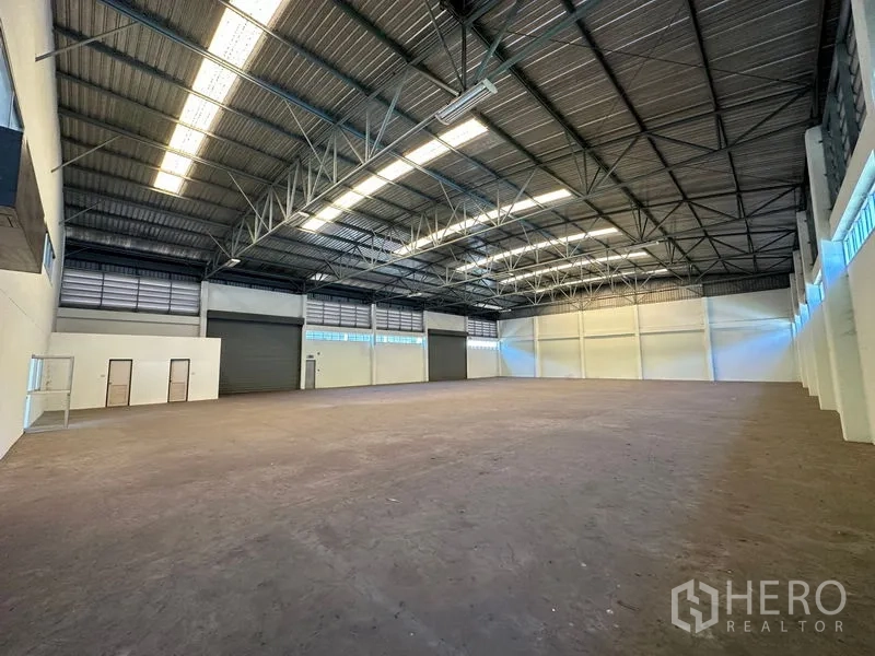 โรงงาน ให้เช่าในChon Buri - ฮอลล์ผลิตโล่งกว้าง มีประตูม้วนหลายจุด เพดานสูง และพื้นคอนกรีตเรียบ