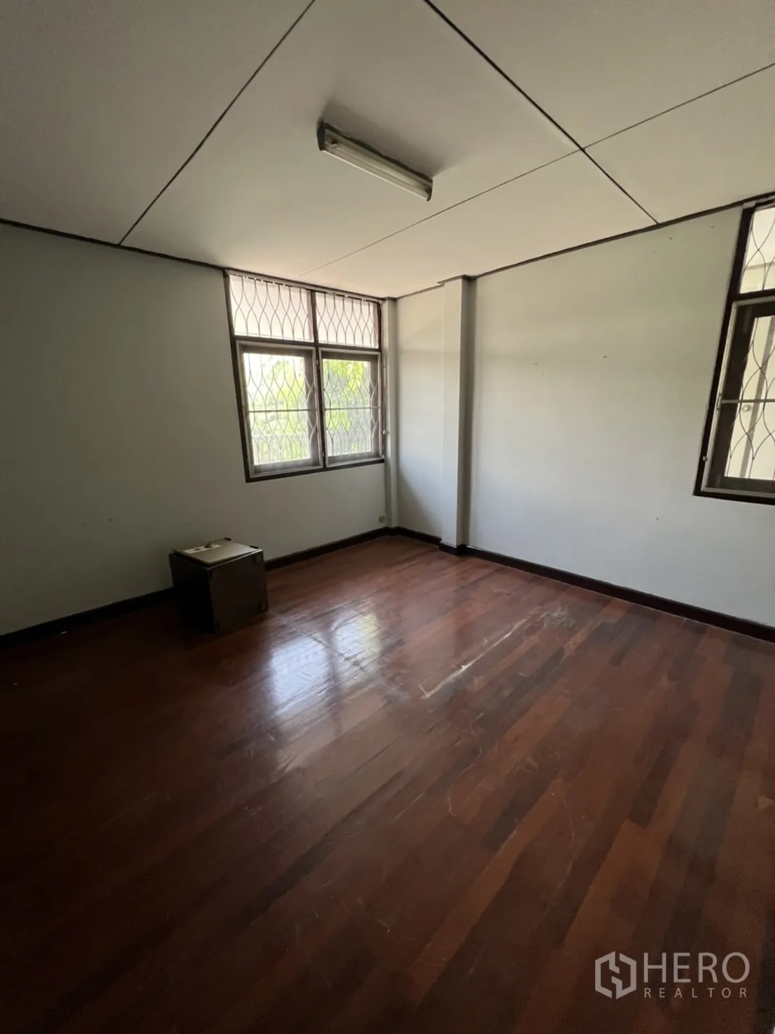 Home Office for rent in Watthana, Bangkok - Bright room with wooden floor and barred windows for ventilation.