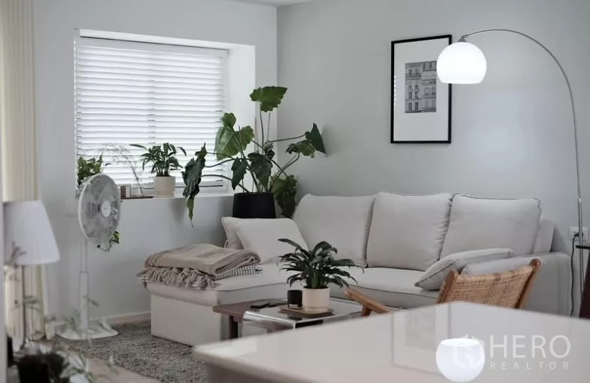 Townhouse for rent in Bang Phli, Samut Prakan - Comfortable sofa nook with window blinds, greenery and a coffee table for relaxing.