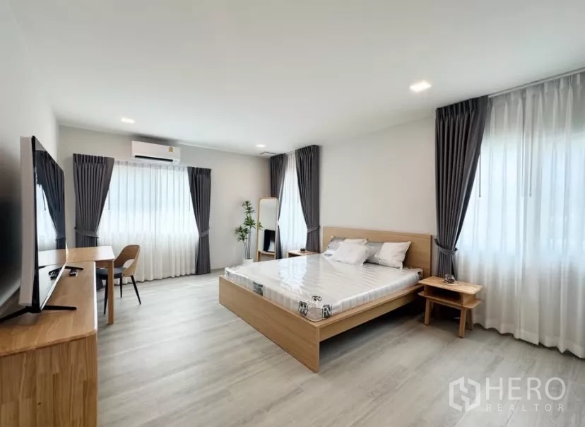 บ้าน ให้เช่าในBang Phli, Samut Prakan - ห้องนอนหลักกว้าง เตียงคิง ทีวีคอนโซล และหน้าต่างขนาดใหญ่