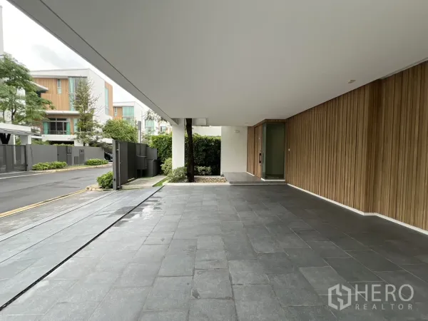 独立式住宅 出租在Saphan Sung, Bangkok - 覆盖式车道与入口，灰色地砖和木墙