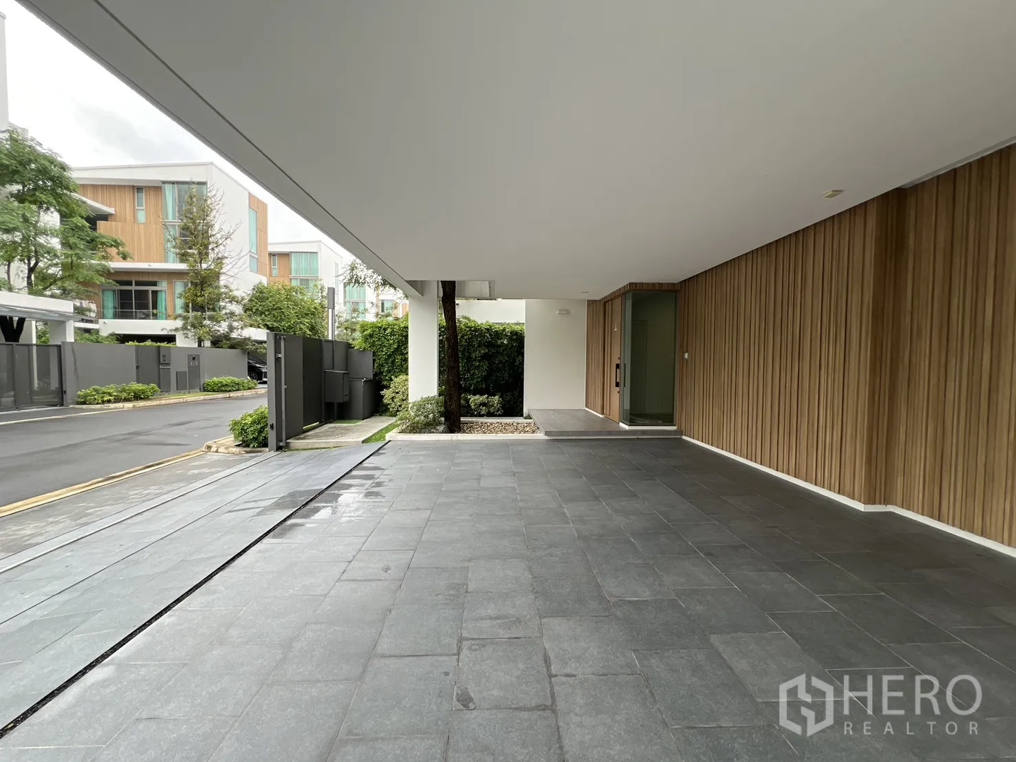 独立式住宅 出租在Saphan Sung, Bangkok - 覆盖式车道与入口，灰色地砖和木墙