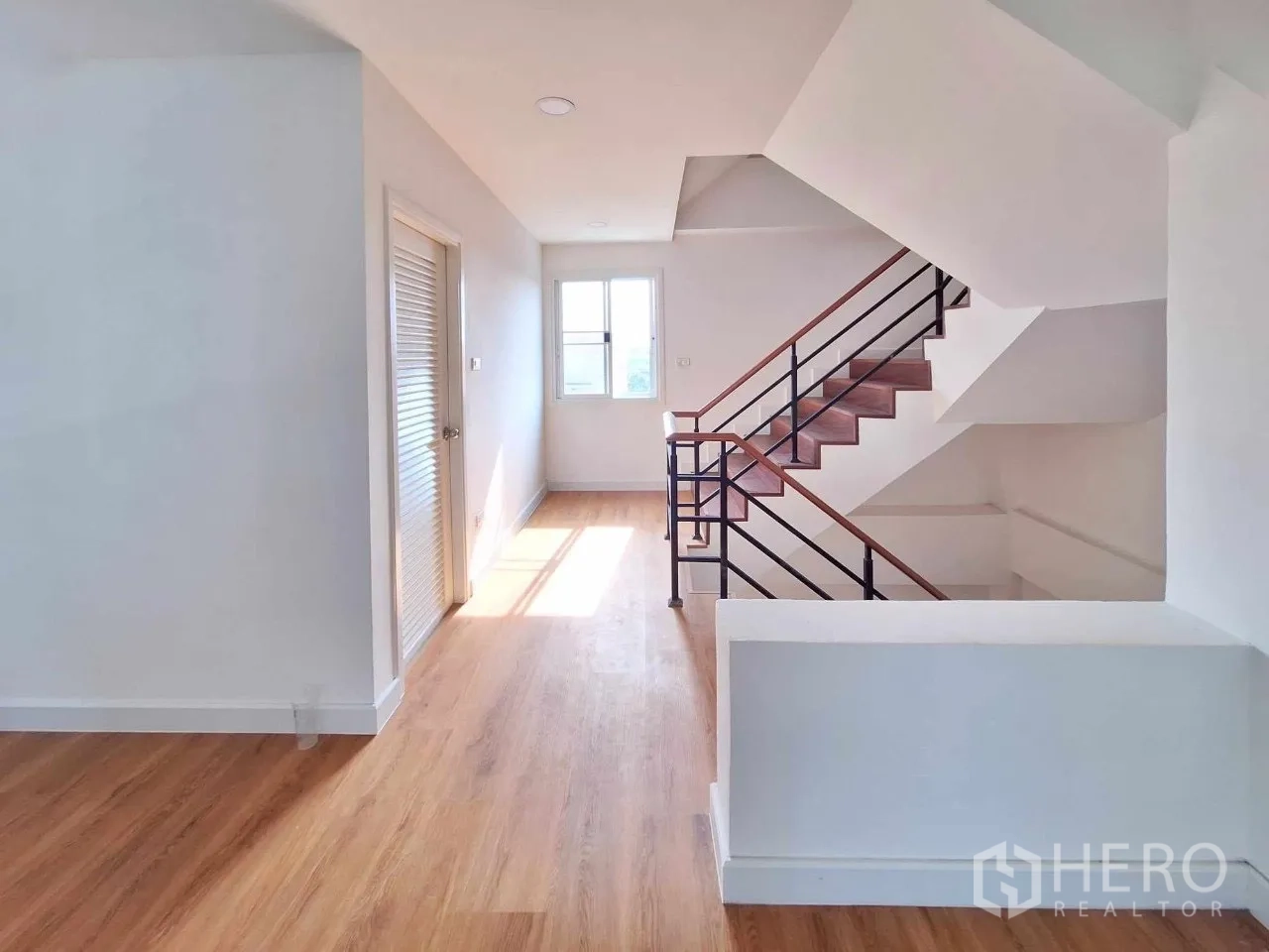 Home Office for sale in Bueng Kum, Bangkok - Stair landing corridor with storage, natural light and wood floors.