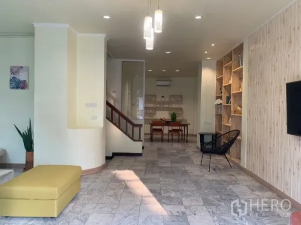 Home Office for rent in Suan Luang, Bangkok - Bright open-plan lobby with built-in shelving, pendant lights and a staircase.