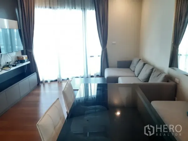 公寓 出租或出售在Khlong Toei, Bangkok - 明亮客餐厅，转角沙发、电视墙与落地窗帘