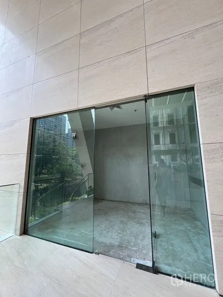 零售空间 出租在Pathum Wan, Bangkok - 临街滑动玻璃门店与石材外墙，靠近轻轨线路。