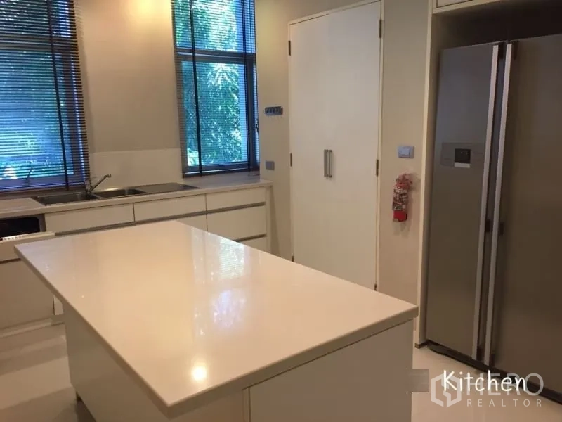 公寓 出租在Sathon, Bangkok - 现代白色厨房，中岛台、内置柜与大窗户。