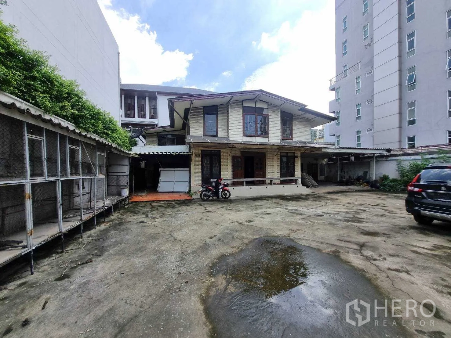 Detached House for rent or sale in Watthana, Bangkok - Two-storey detached house in Thonglor with large concrete courtyard and parking area.
