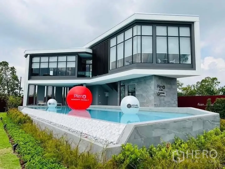Townhouse for rent in Bang Phli, Samut Prakan - Modern glass-fronted clubhouse building with an elevated swimming pool.