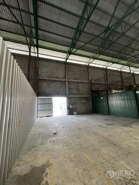 货栈 出租在Prawet, Bangkok - 仓库内开阔存储区，金属墙板与大门，自然采光