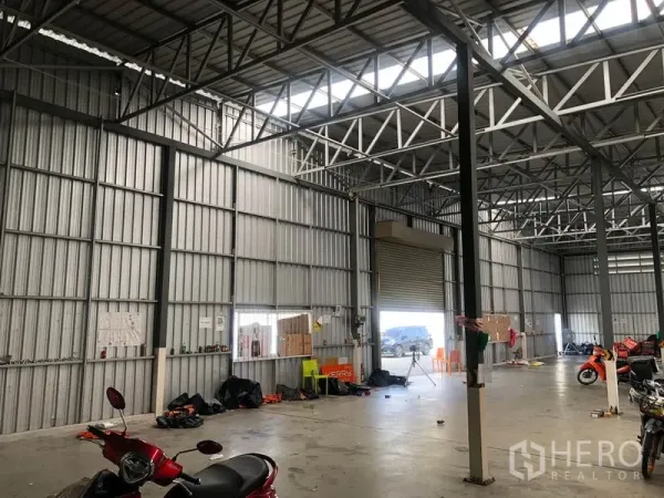 Warehouse for rent in Don Mueang, Bangkok - High-clearance warehouse wall showing roller shutter door and clerestory skylights.