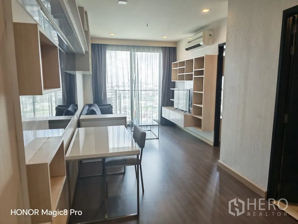 คอนโด for rent in Watthana, Bangkok - ทางเดินสู่ห้องนั่งเล่น มีโต๊ะทานอาหารผิวเงา ชั้นวางทีวี และหน้าต่างบานใหญ่