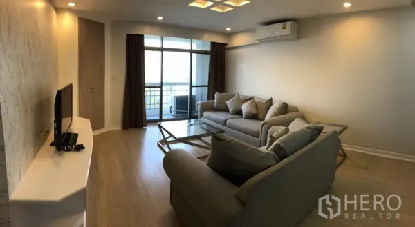 公寓 出租在Watthana, Bangkok - 客厅设沙发组、电视柜、吸顶灯，推拉门通向阳台。