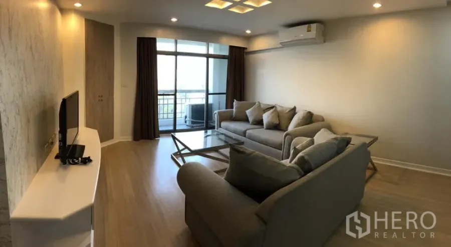 公寓 出租在Watthana, Bangkok - 客厅设沙发组、电视柜、吸顶灯，推拉门通向阳台。