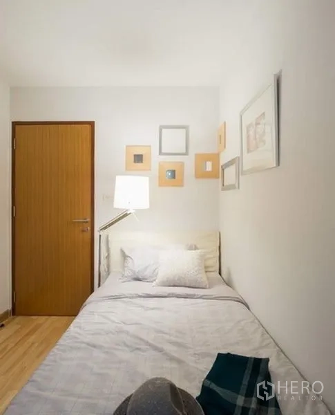 คอนโด ให้เช่าหรือขายในPhra Khanong, Bangkok - ห้องนอนที่สามเตียงเดี่ยว ผนังประดับกรอบรูป และประตูไม้สไตล์มินิมอล.