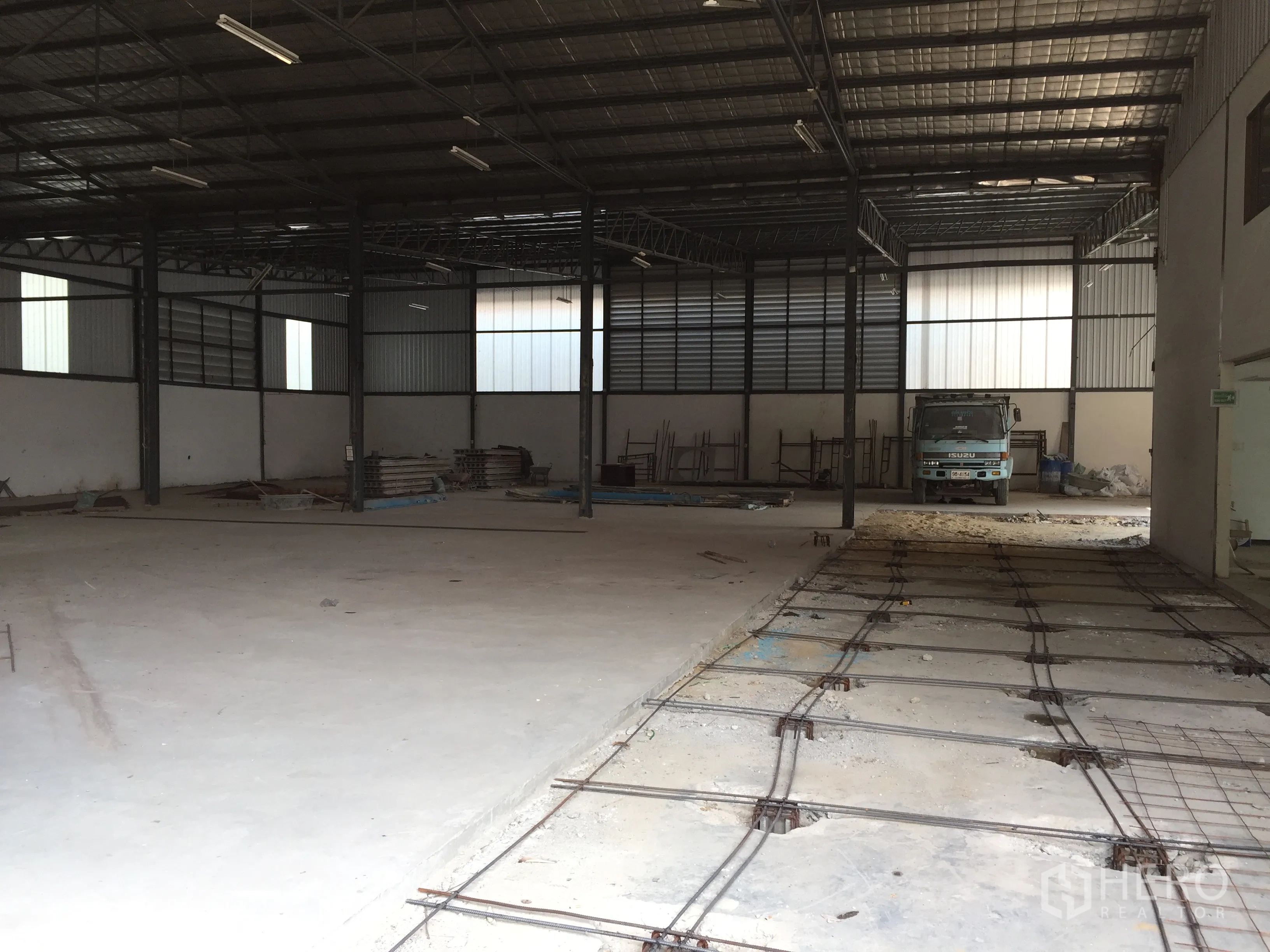 货栈 出租在Saphan Sung, Bangkok - 工业仓库设有加固地坪沟槽、高位照明与装卸作业区，内有卡车停靠。