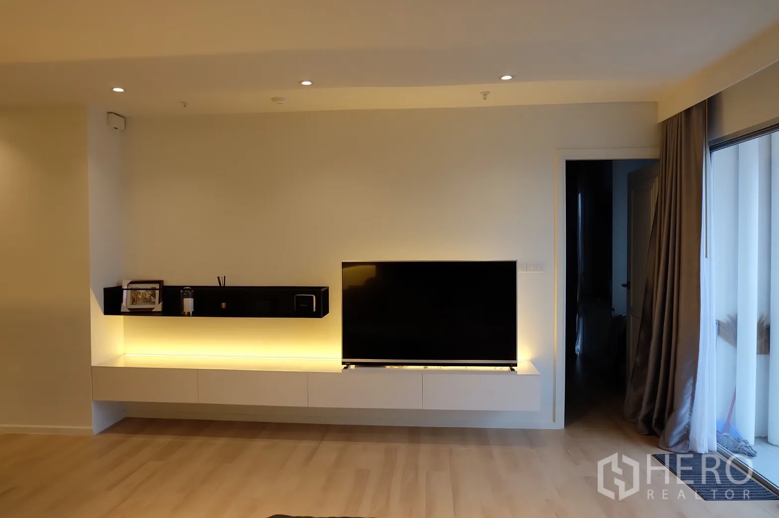 公寓 出租在Bang Rak, Bangkok - 电视柜与悬浮置物架，落地推门通往阳台。