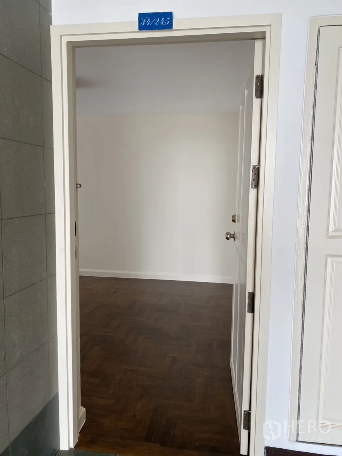 คอนโด ให้เช่าในWatthana, Bangkok - ประตูเปิดสู่ห้องผนังสีขาว พื้นปาร์เกต์ไม้