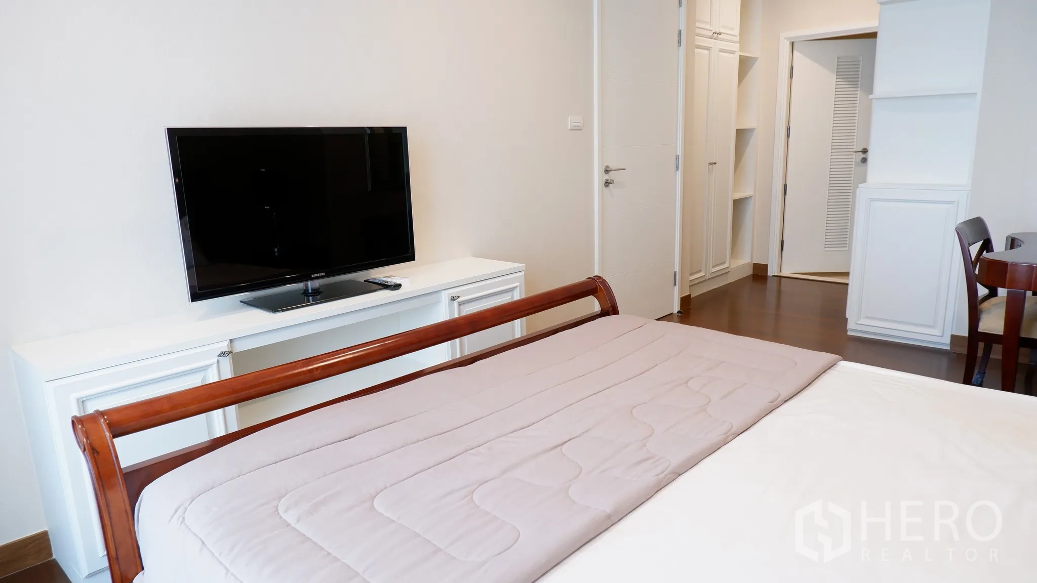 Condominium for rent in Watthana, Bangkok - Master bedroom view toward TV unit, wardrobes, and shelving.