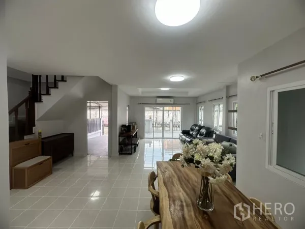 ทาวน์เฮาส์ ขายในLam Luk Ka, Pathum Thani - พื้นที่นั่งเล่นและรับประทานอาหารแบบโอเพนแปลนสว่าง พร้อมบันไดและประตูกระจกบานเลื่อน