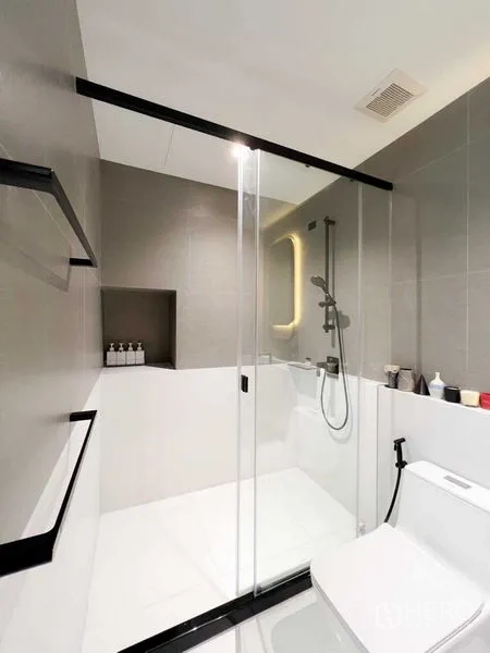 Condominium for rent or sale - Bathroom angle showing sliding glass shower door and tiled walls.