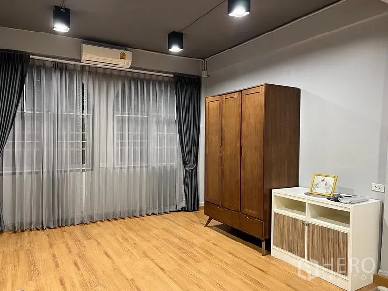 Shophouse for sale in Bang Kho Laem, Bangkok - Empty bedroom with air conditioner, large windows and wood wardrobe.