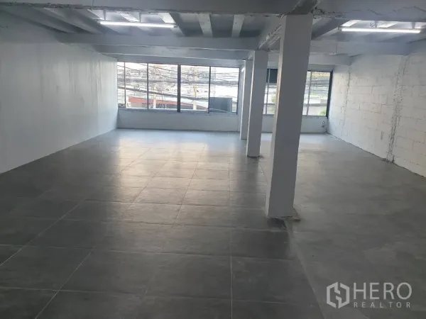 零售空间 出租在Khlong Toei, Bangkok - 大开间零售区域，多根柱体、灰色地砖与落地窗引入充足自然光。