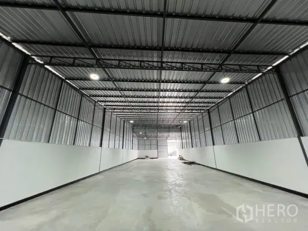 คลังสินค้า ให้เช่าในSaphan Sung, Bangkok - ฮอลล์เก็บสินค้าแบบช่วงกว้าง ผนังเมทัลชีท มีแผ่นรับแสง และประตูทางเข้าด้านท้าย