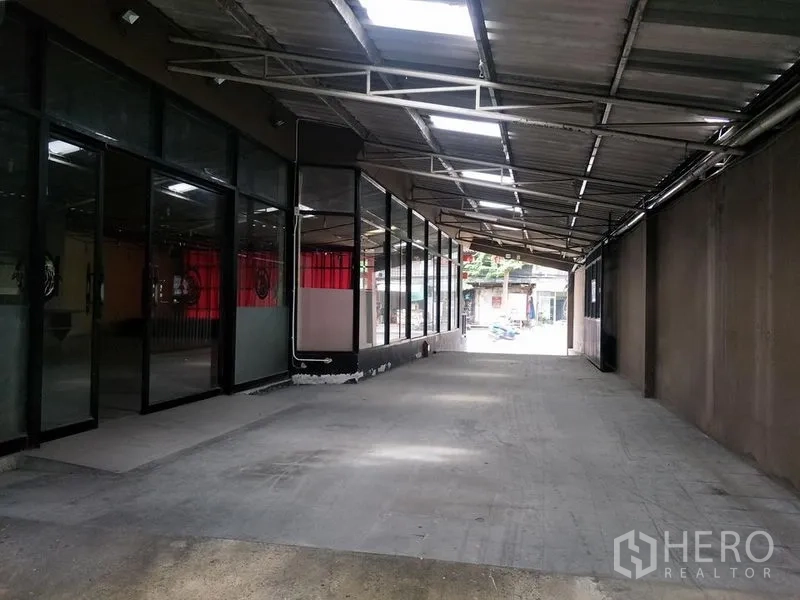 零售空间 出租在Khlong Toei, Bangkok - 带顶长通道，一侧为玻璃店面墙，混凝土通车道便于装卸与停车。
