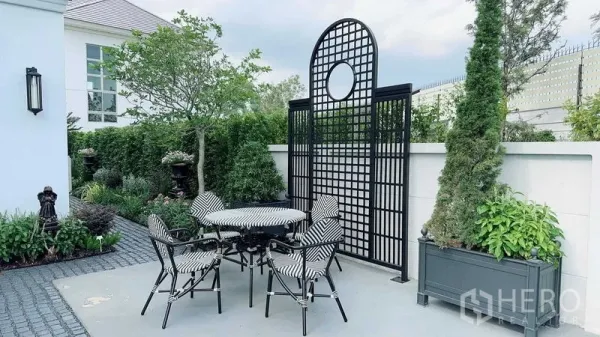 บ้าน ขายในLat Krabang, Bangkok - ลานนั่งเล่นกลางสวนพร้อมฉากระแนงเหล็กและชุดโต๊ะเก้าอี้