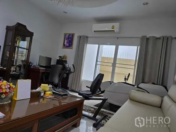 ที่ดิน ขาย - มุมทำงานพร้อมโต๊ะทำงาน แอร์ และจักรยานออกกำลังกายข้างหน้าต่าง