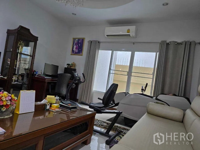 ที่ดิน ขาย - มุมทำงานพร้อมโต๊ะทำงาน แอร์ และจักรยานออกกำลังกายข้างหน้าต่าง