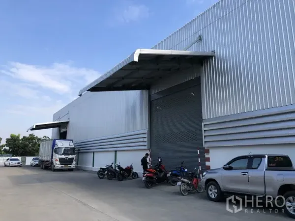 Warehouse for rent in Pathum Thani - Front of corrugated steel warehouse in Bang Khu Wat with wide roller shutter, canopy loading bay and truck access.