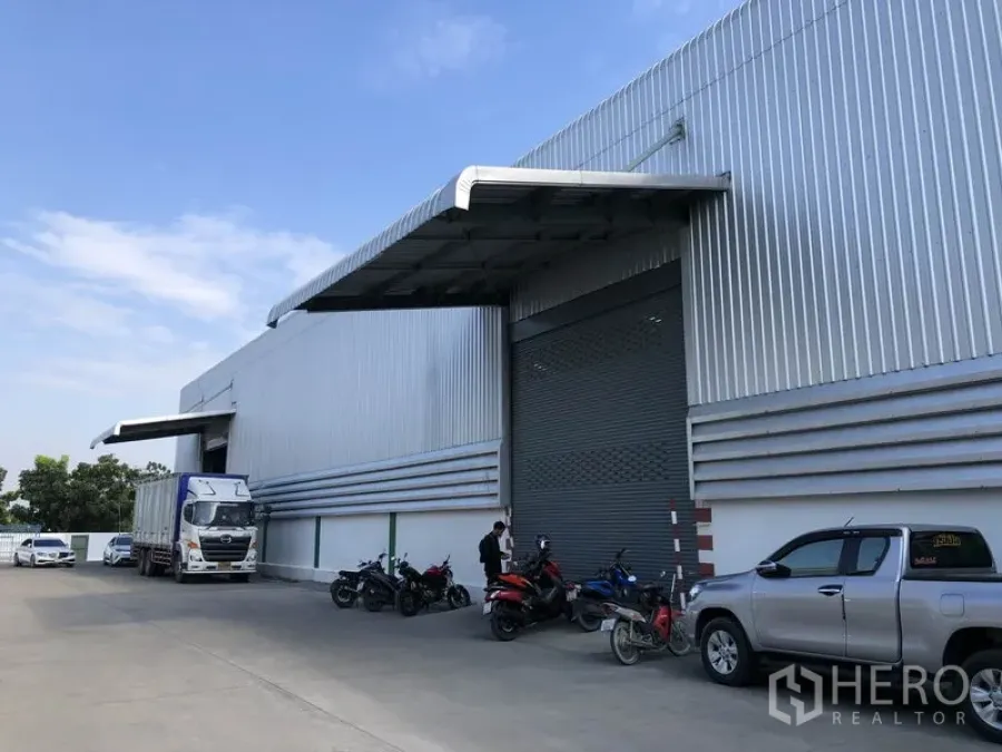 Warehouse for rent in Pathum Thani - Front of corrugated steel warehouse in Bang Khu Wat with wide roller shutter, canopy loading bay and truck access.