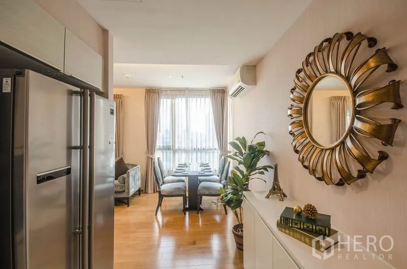 คอนโด ให้เช่าหรือขายในWatthana, Bangkok - โถงทางเดินสู่โซนทานข้าว มีกระจกทรงพระอาทิตย์ กระถางต้นไม้ และแสงธรรมชาติ