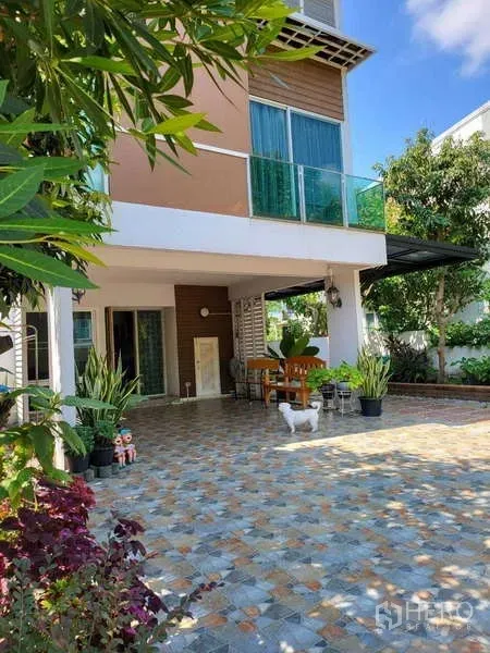 บ้าน ให้เช่าในLat Krabang, Bangkok - ลานหน้าบ้านปูกระเบื้องของบ้านเดี่ยวสไตล์โมเดิร์น พร้อมมุมนั่งเล่นและกระถางต้นไม้