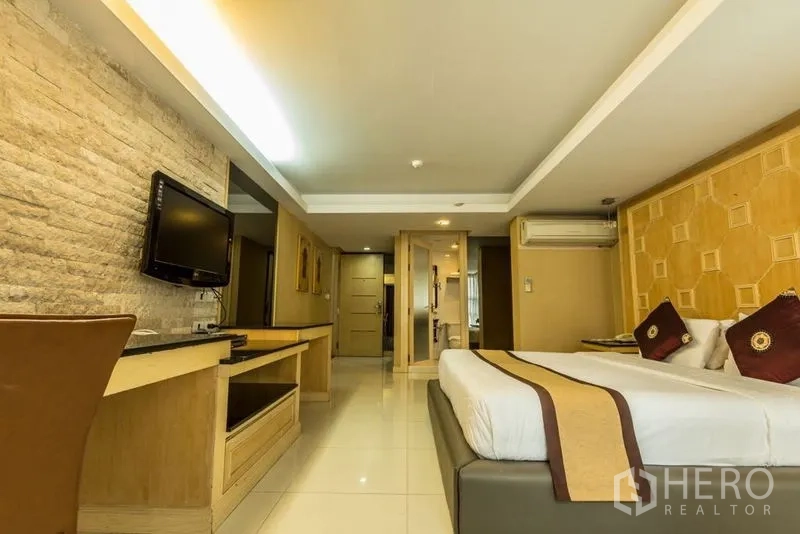 พื้นที่ขายปลีก ให้เช่า - พื้นที่แบบห้องนอน มีผนังติดทีวี ผนังหินตกแต่ง และโต๊ะทำงานบิลท์อิน