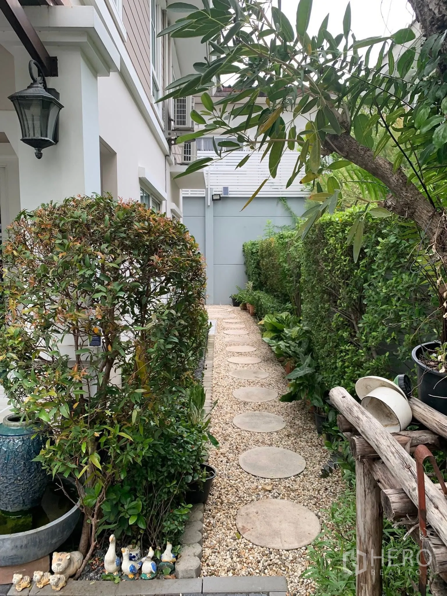 Townhouse for rent or sale in Sai Mai, Bangkok - Lush garden path with circular stepping stones and dense hedges.