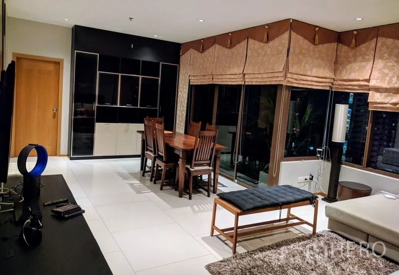 คอนโด ให้เช่า - พื้นที่นั่งเล่นและรับประทานอาหาร มีตู้โชว์สีดำ ชุดโต๊ะอาหาร และประตูกระจกไประเบียง